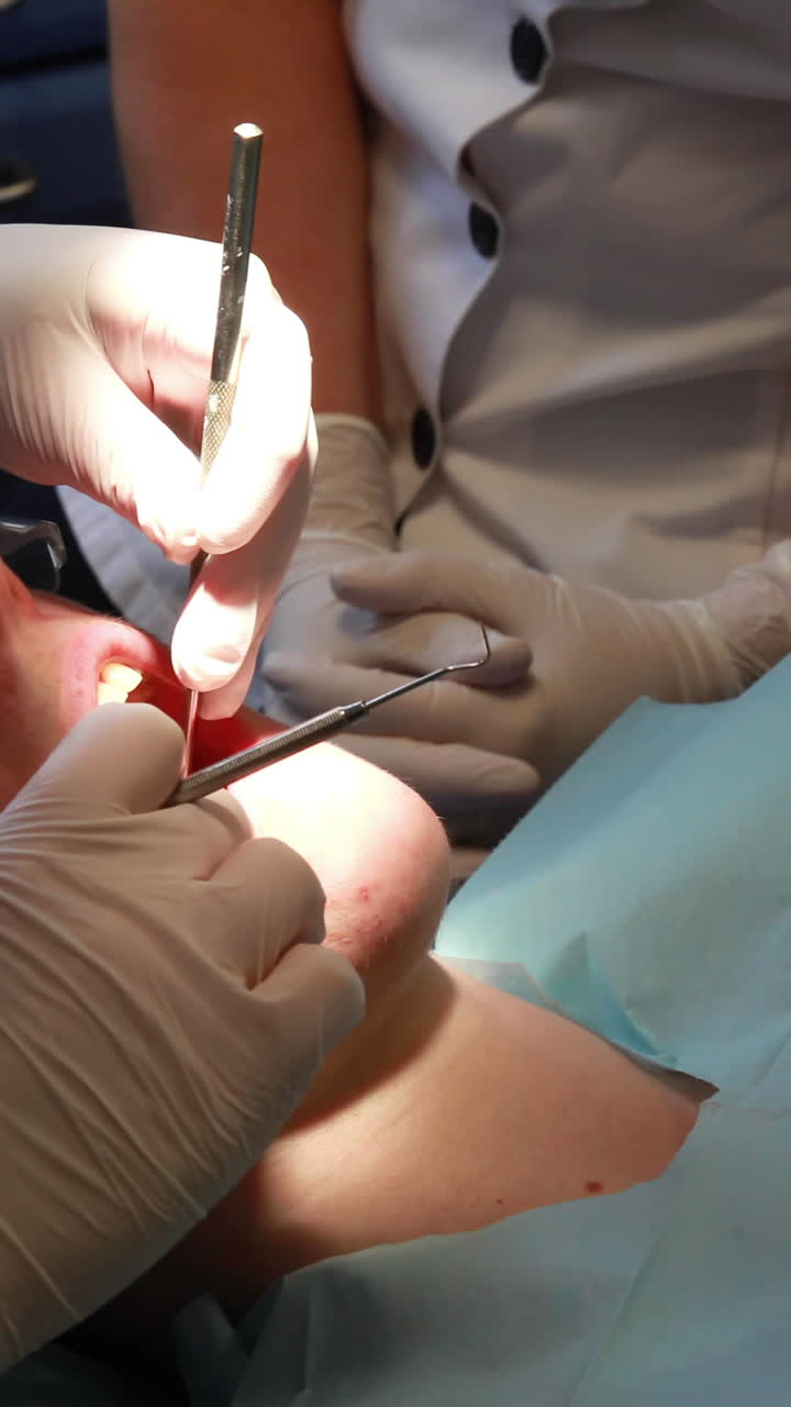 dentista examinando los dientes de un paciente bajo una luz brillante.