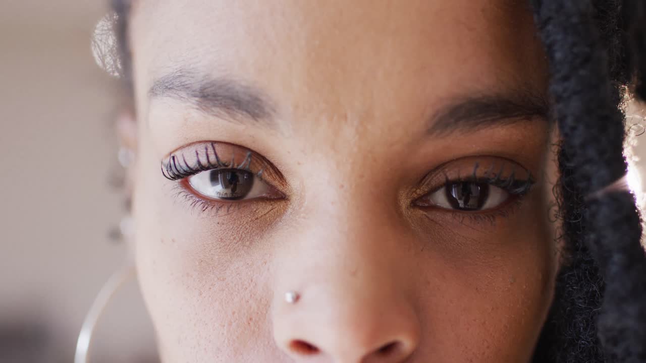 retrato de una feliz mujer biracial mirando a la cámara en un estudio de baile, cámara lenta