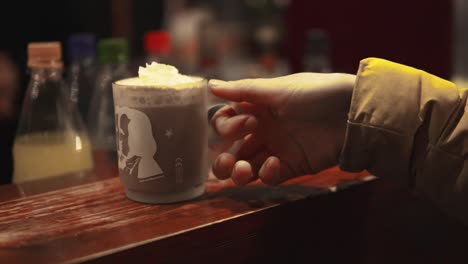 person taking their hot choclate on a christmas market that she just ordered