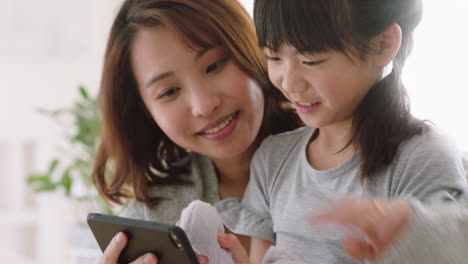 asian mother and child using smartphone having video chat little girl with mom waving sharing vacation weekend with daughter enjoying chatting on mobile phone 4k footage