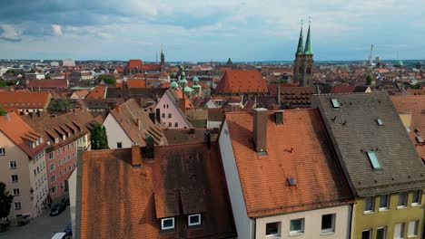 4k aerial drone video of copper-clad cupolas, church spiers, and tiled rooftops of the skyline of downtown nurnberg, germany