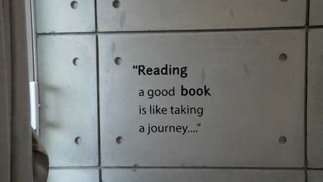 book reading quote on the white tiled wall in a house - simple interior concept - close up