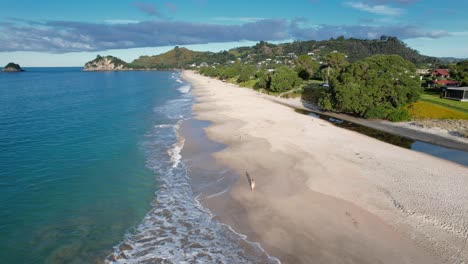 aerial view of a serene coastal beach with turquoise waters and distant hills