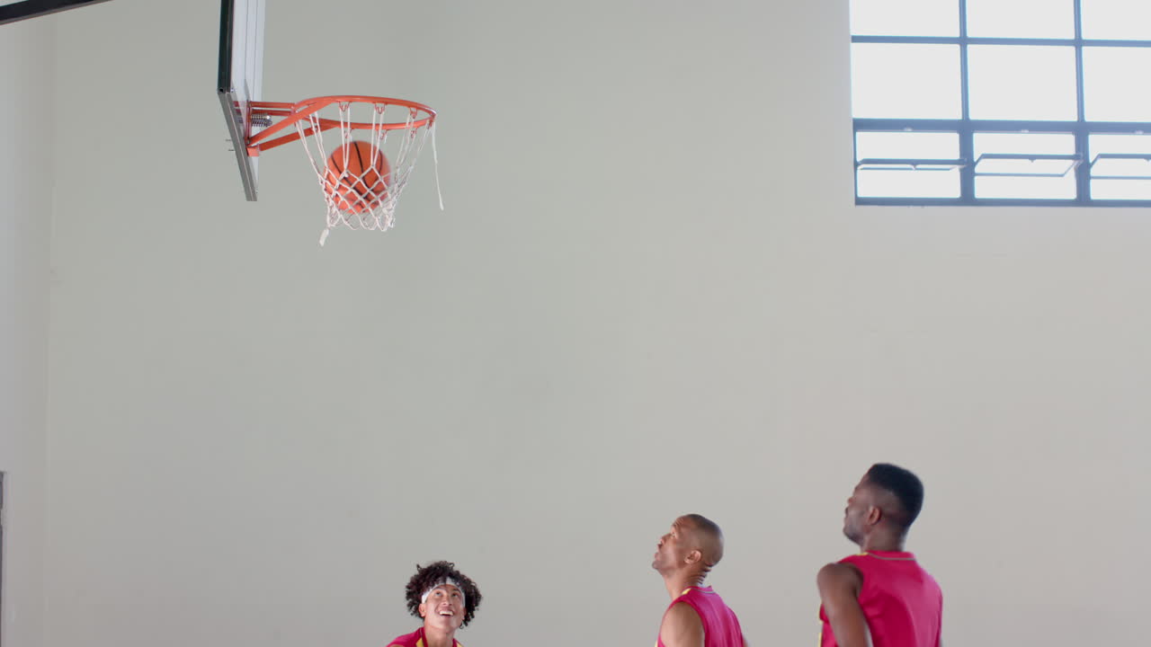 jóvenes afroamericanos jugando al baloncesto en el interior