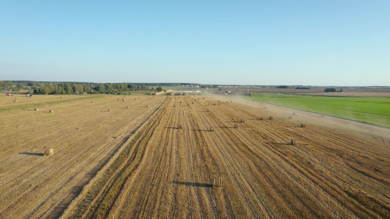 Flug über ein ländliches Feld mit gewundenen Heuballen nach der Ernte