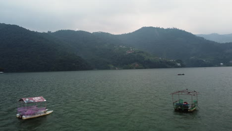 traditional canoe fishing boats and tourists water transport in lake of pokhara nepal