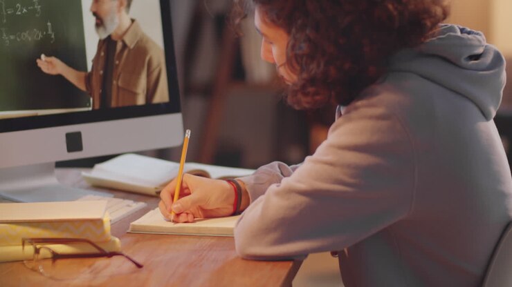 Ragazzo adolescente che segue una lezione scolastica online in videochiamata a casa