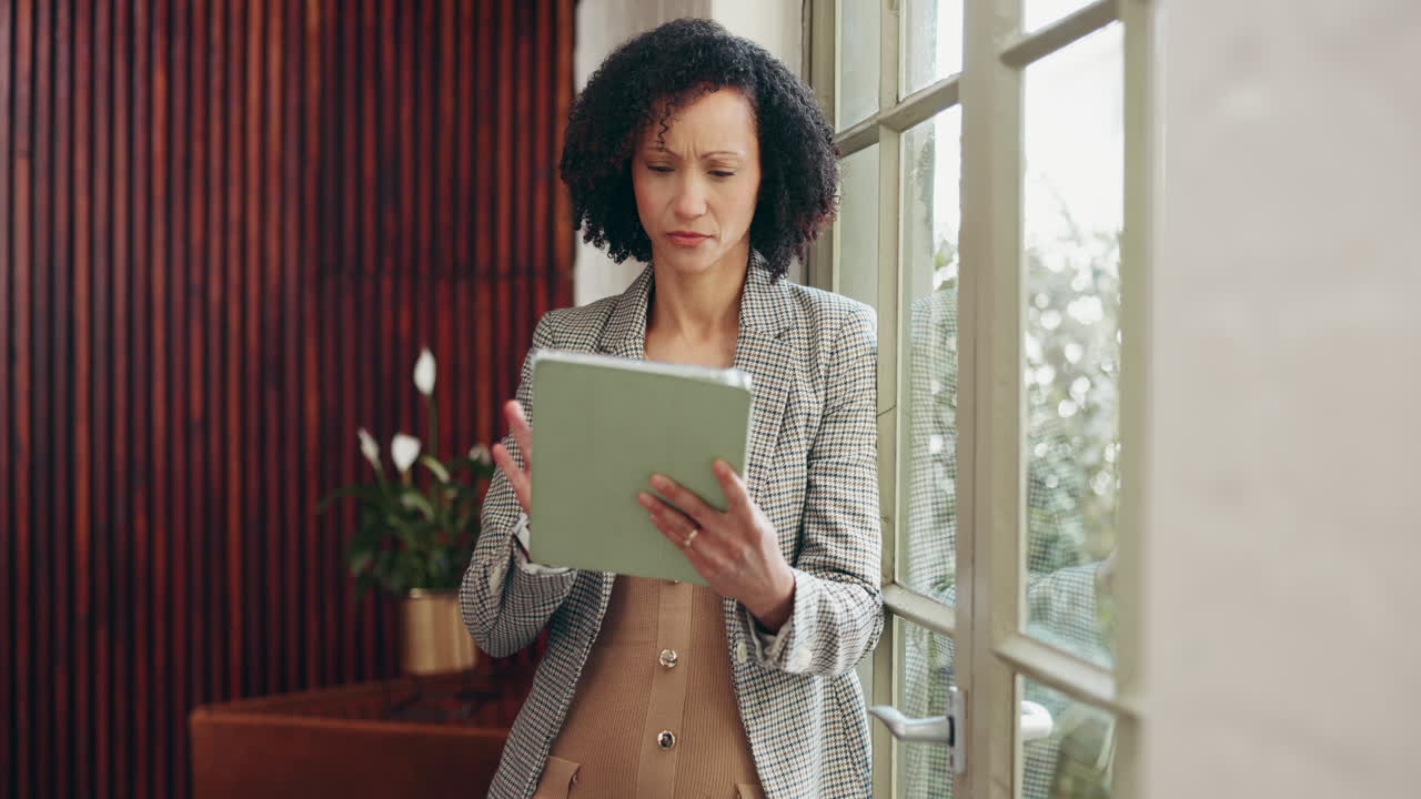 Businesswoman using tablet by the window