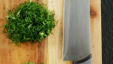 chopped herbs with knife on chopping board 4k