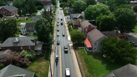 La-Línea-De-Tráfico-De-Automóviles-Sigue-A-Los-Carruajes-De-Caballos-Y-Buggy-Amish-A-Través-De-La-Ciudad-Estadounidense