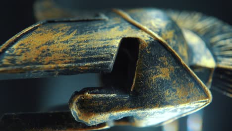 A-vertical-close-up-macro-cinematic-shot-of-a-spartan-face-design,-warrior-metal-bronze-helmet,-on-a-360-rotating-stand,-studio-lighting,-4K-video