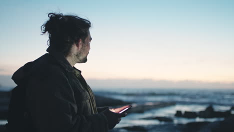 Beach,-sunset-and-man-on-smartphone-for-travel