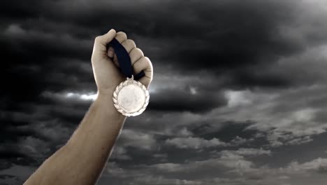 la mano del atleta con la medalla de oro
