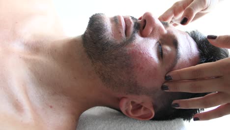 young man getting a head massage in a spa