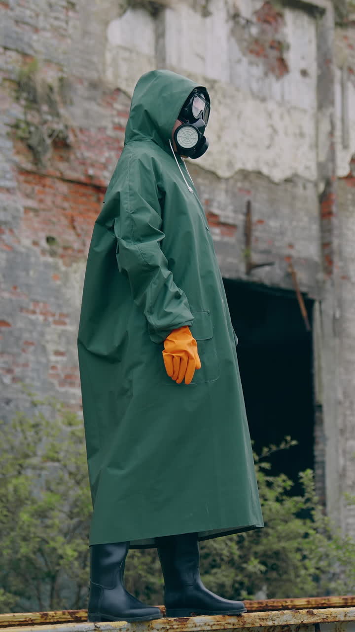 Man in protective mask on ruins. Dramatic portrait of man wearing gas mask near ruined building