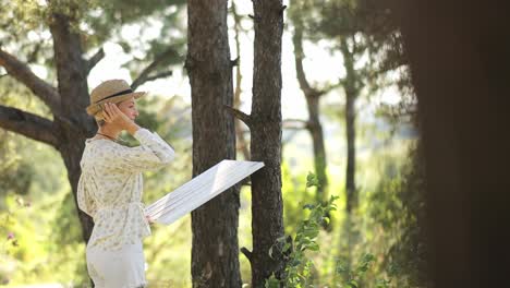 beautiful girl artist outdoors background landscape and creates creativity in the forest in summer - a girl artist paints a picture in a pine forest. beautiful girl artist outdoors. background landscape and creates creativity in the forest in summer