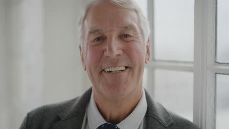 portrait-of-elderly-caucasian-man-laughing-enjoying-success-looking-at-camera-standing-window-background-senior-male-retirement-slow-motion