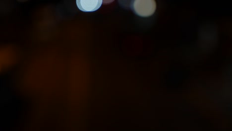 hermoso bokeh brillante en el fondo oscuro borroso por la noche. el redondo bokeh colorido brilla de las luces de los coches en la calle de la ciudad. fuera de foco con borroso. luces de la ciudad sin enfoque. bokeh de tráfico. concepto abstracto