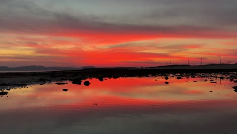 scenic landscape of colorful orange sunset at beach the sand beach seaside rock water pond in tidal time tide move sea level back and low then beautiful landscape reveals in qeshm island iran gulf