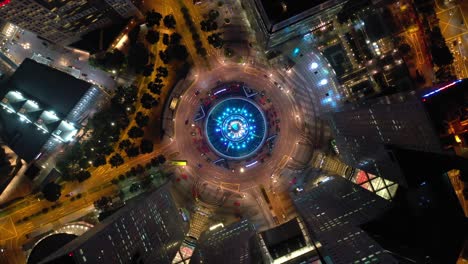 night illumination flight over singapore city famous downtown traffic circle aerial topdown panorama 4k