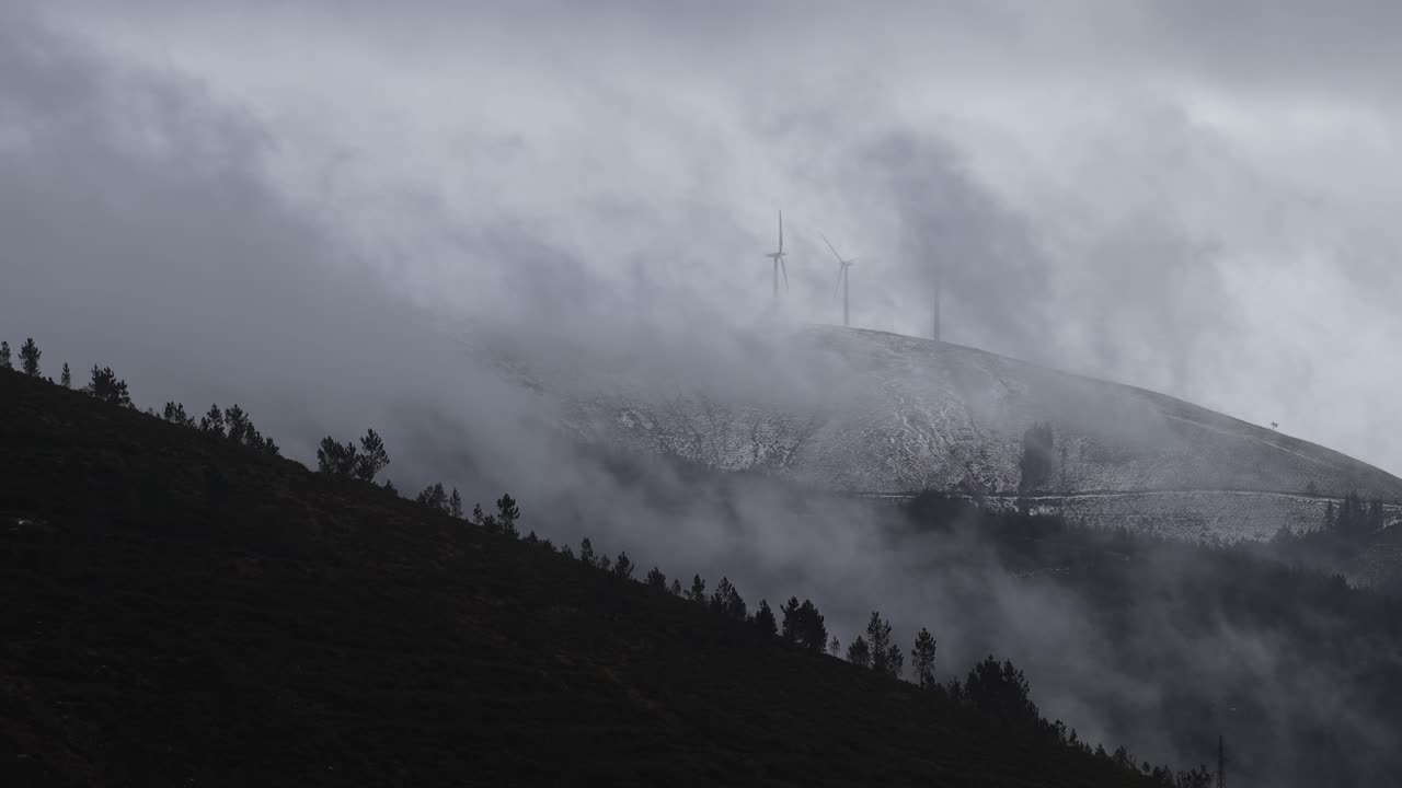 Nuvole e neve in cima alle montagne con nuvole in rapido movimento.