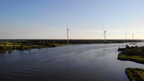 Lufttransportwagen-Vorwärts-über-Oude-Maas-Mit-Stillstehenden-Windkraftanlagen-Und-Der-Silhouette-Eines-Schiffes,-Das-Sich-In-Der-Ferne-Nähert