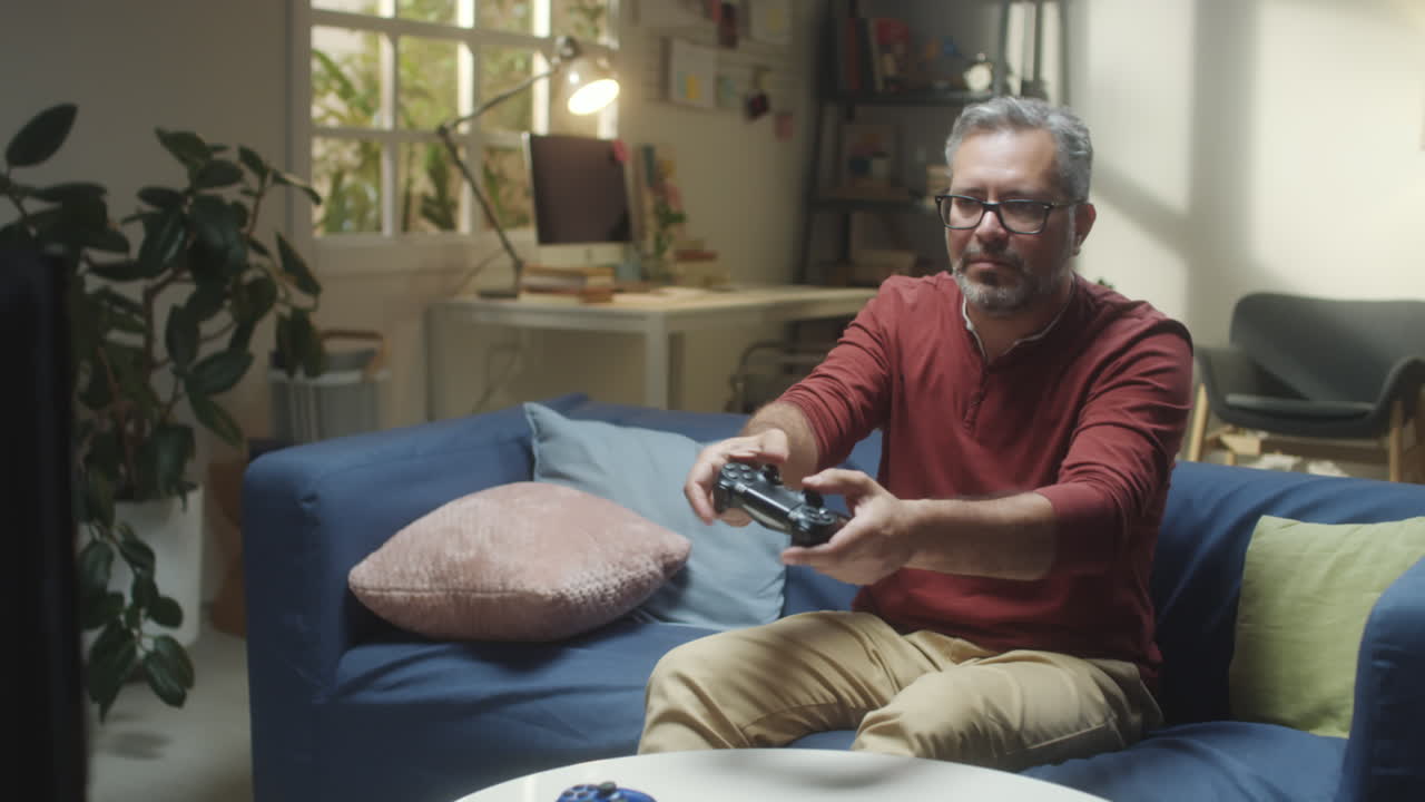 Man playing video games on a couch in a living room