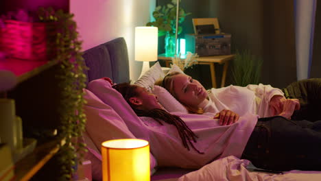 una pareja acostada en la cama hablando por la noche.