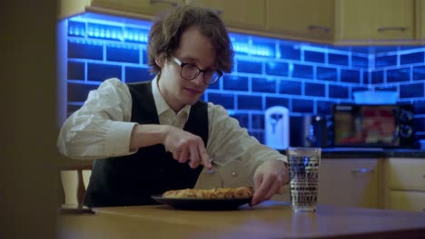 un joven corta su pizza lista para comer