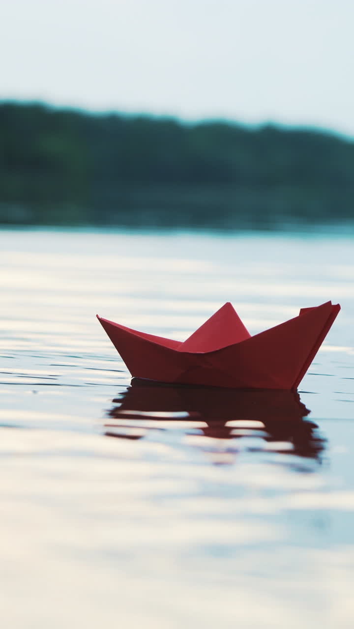 Paper boat floating on water Vertical video