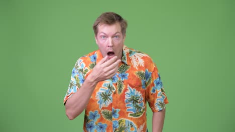 young handsome tourist man looking shocked