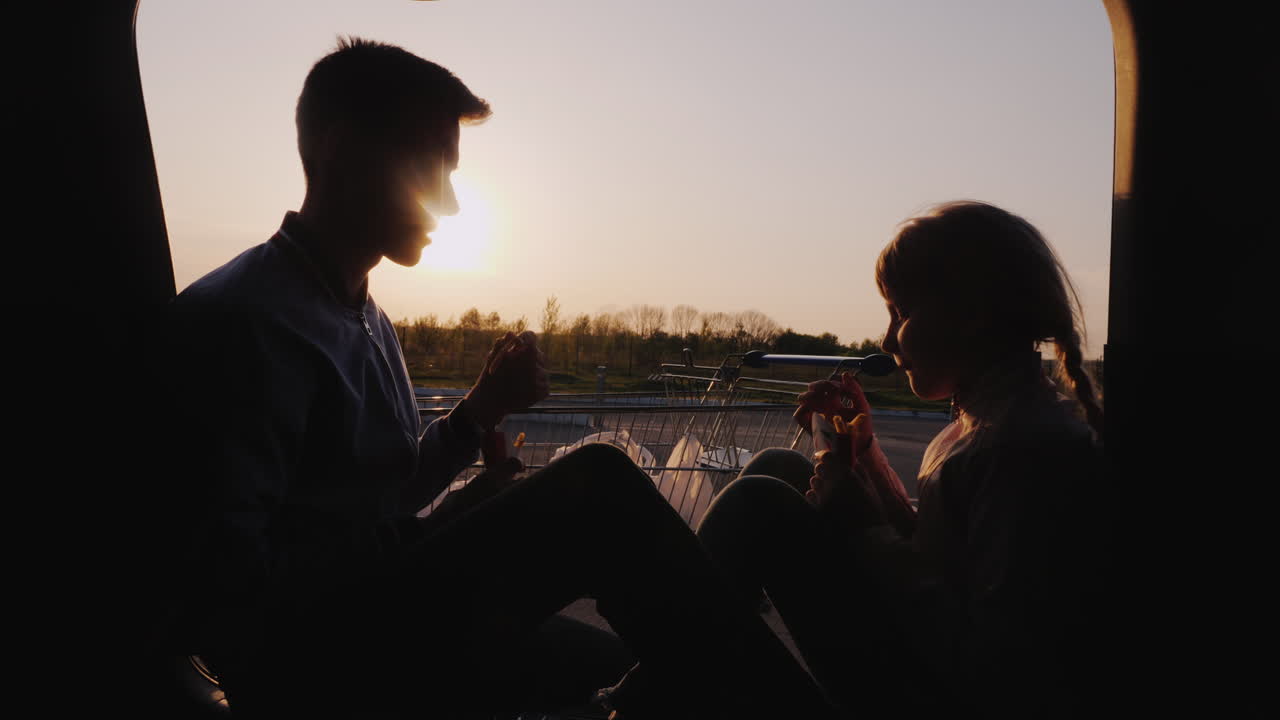 여동생이 있는 십대는 자동차 여행에서 주유소 휴식에서 간식을 먹을 것입니다