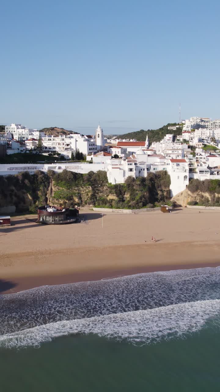 Vertikale Luftaufnahme einer malerischen Küstenstadt mit felsigen Klippen in Albufeira, Portugal.