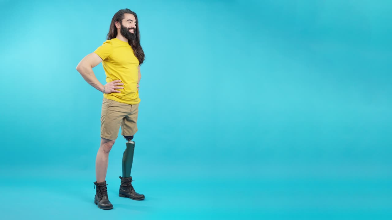 Man with prosthetic leg standing confidently against a blue background