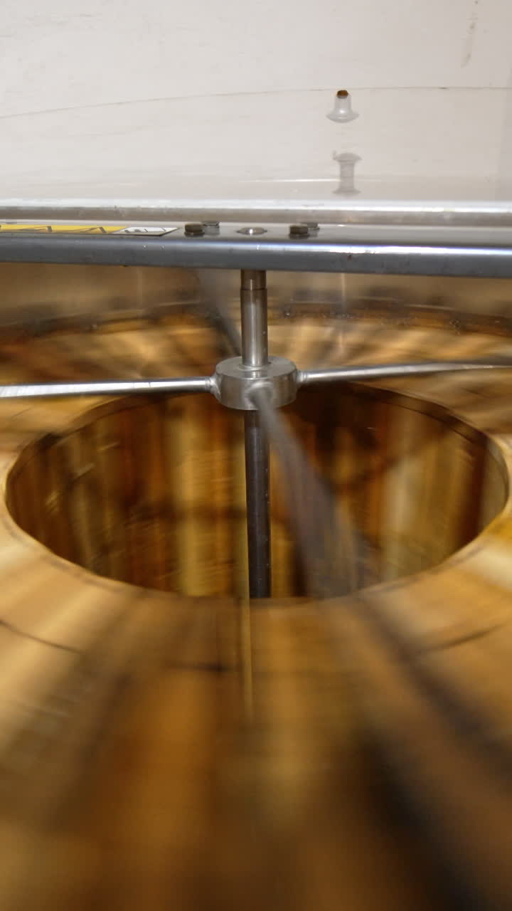 Organic honey production at bee farm. Apparatus spins the wooden frames to extract fresh healthy product from honeycombs. Vertical video