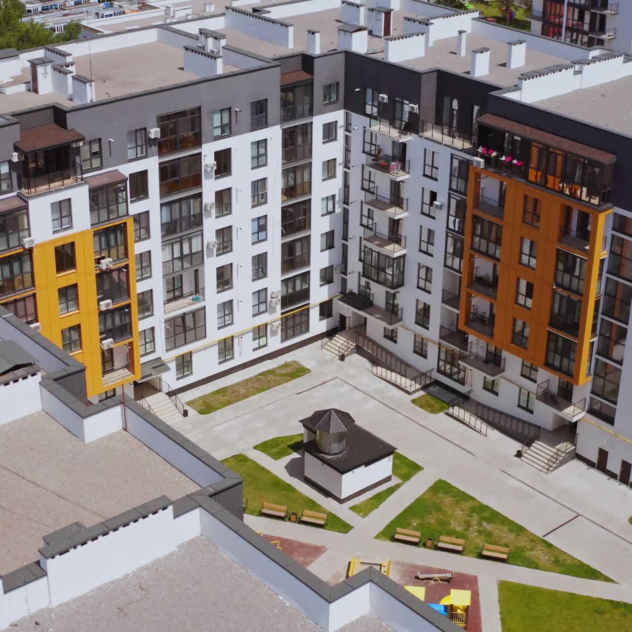 New residential complex. High-rise buildings built together. Comfortable playground for kids surrounded by apartment buildings. Top aerial view