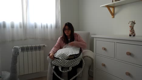 pregnant woman checking the hospital bag in a rocking chair