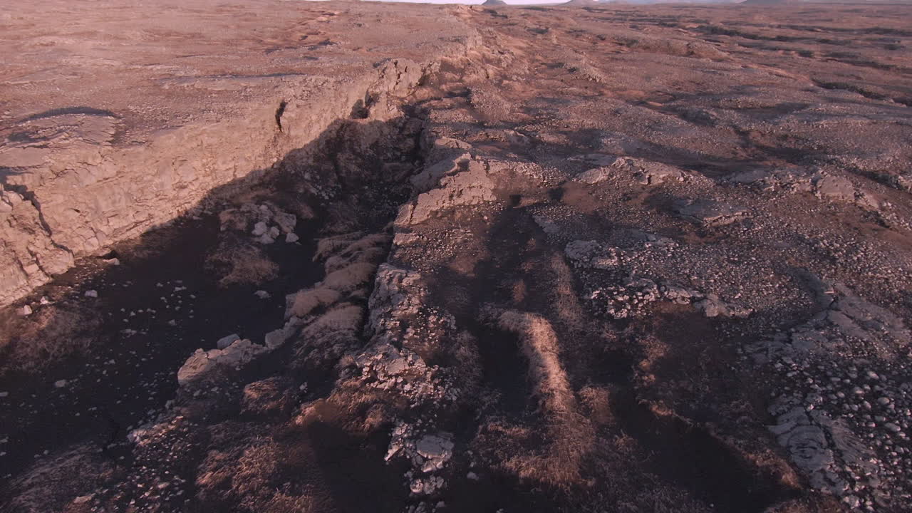 Carrellata in avanti sopra i crepacci di un campo lavico al caldo tramonto, Islanda.