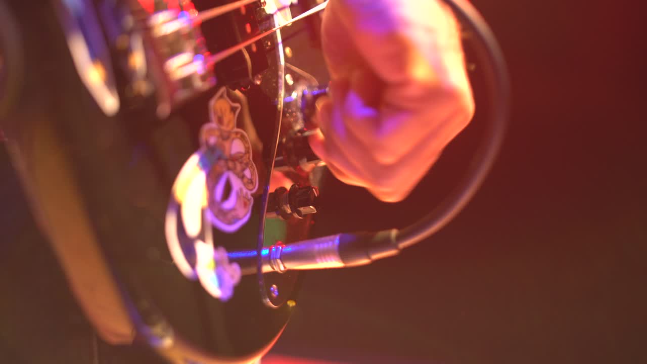 bajista que conecta el instrumento y las perillas móviles en el escenario