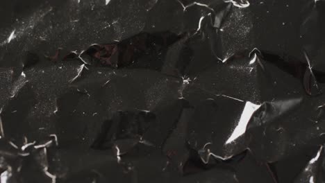 Close-up-of-black-crumpled-plastic-rubbish-bag-in-slow-motion