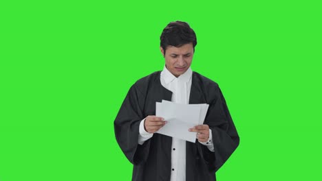 abogado indio enojado leyendo contratos pantalla verde