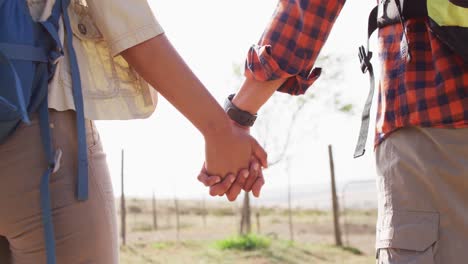 Happy-african-american-couple-with-backpacks,-hiking-together-on-sunny-day,-slow-motion