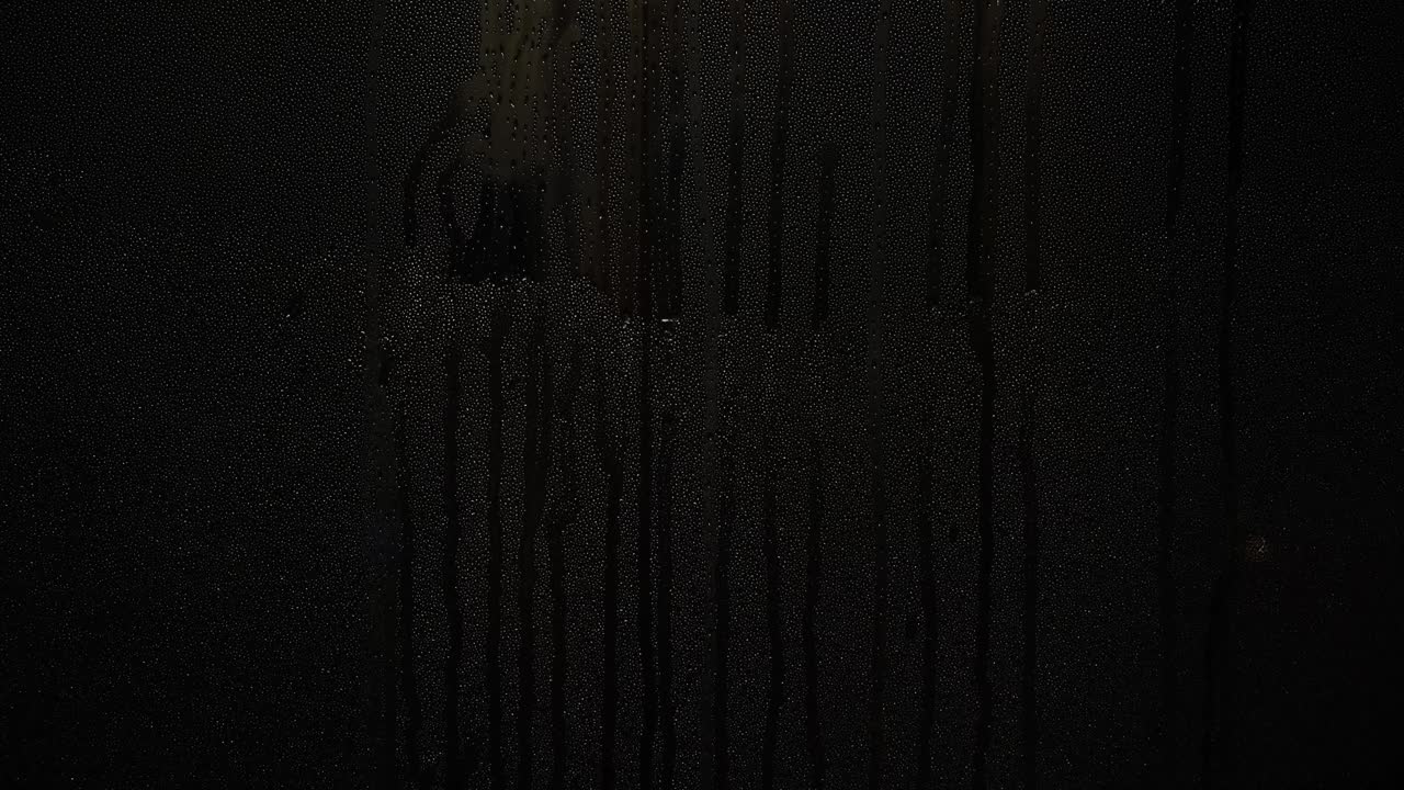 밤의 창문에 물방울이 떨어집니다.