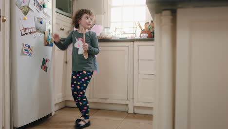 happy-little-girl-dancing-in-kitchen-wearing-cute-fairy-wings-having-fun-waving-spoon-playing-pretend-doing-funny-dance-moves-enjoying-weekend-at-home