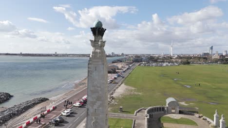 Drone-flight-passing-close-by-Navy-War-Memorial-Southsea-with-Southsea-Common-and-sea-front-and-views-towards-Portsmouth-docks-on-bright-sunny-day