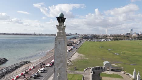 vuelo de avión no tripulado pasando cerca del memorial de guerra de la armada southsea con southsea común y frente al mar y vistas hacia los muelles de portsmouth en un día soleado y brillante