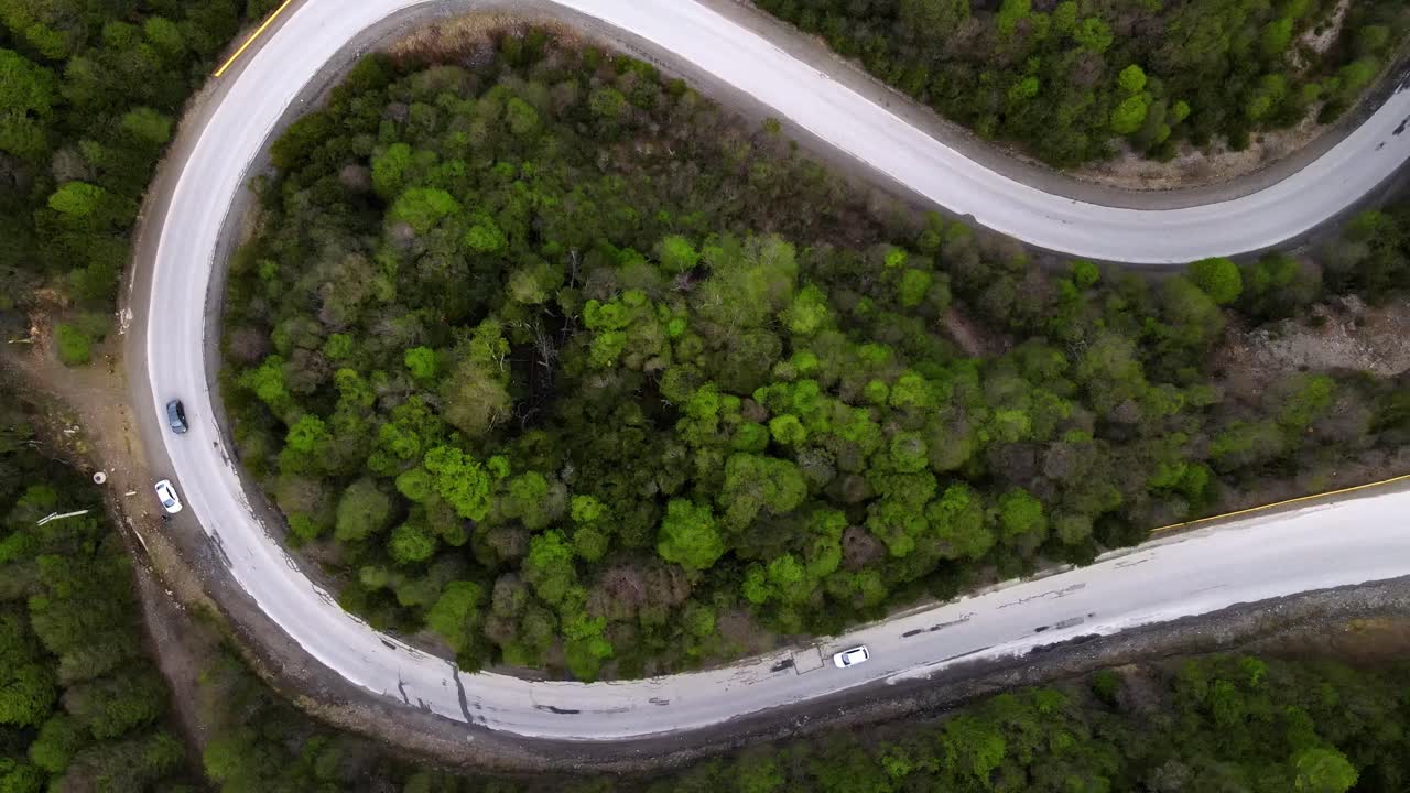 un avión no tripulado sube sobre una carretera sinuosa y curva que sube a las montañas de los andes en ushuaia, argentina.