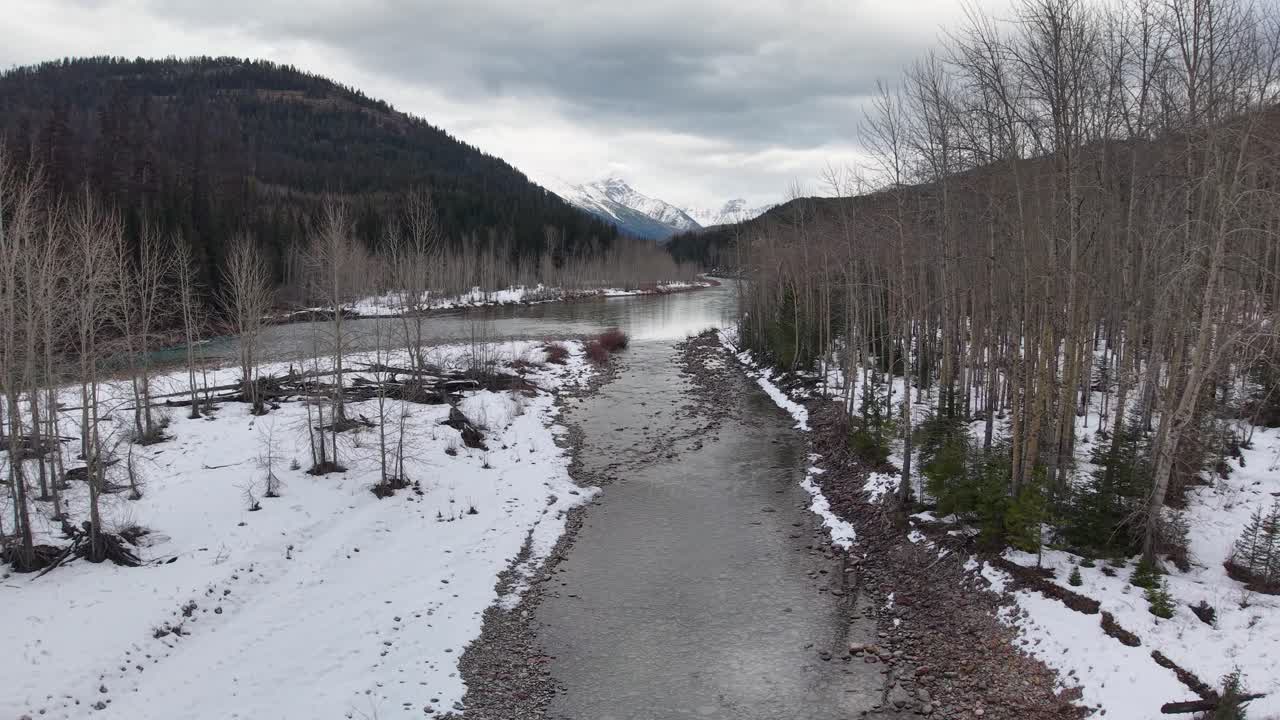 Ilmakuva alas talvista Flathead-jokea pitkin Montanan vuorten halki.