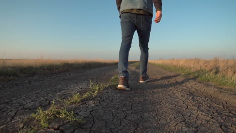 man walking on a dusty country road
