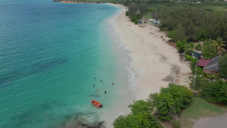 Aerial-establishing-shot-of-group-of-tourist-friends-enjoy-caribbean-holidays-in-Antigua-and-Bermuda,-stay-in-cottage-houses